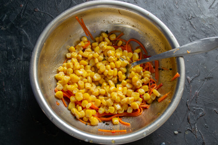 Adding Sweet Corn Canned sweet corn added to the marinated carrots
