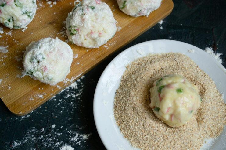 Coating in breadcrumbs Crab croquette covered in breadcrumbs on a white plate
