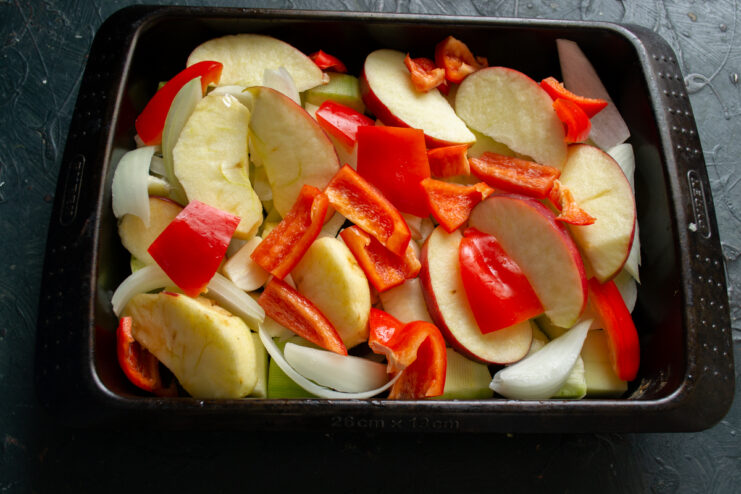 Adding sweet bell peppers Roughly chopped sweet red bell peppers added to the roasting pan
