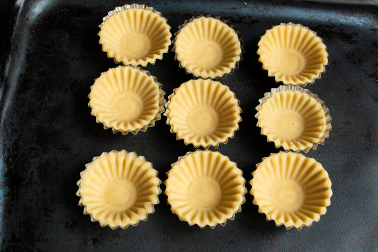 Forming the tartlet shells Circles of dough pressed into metal baking molds