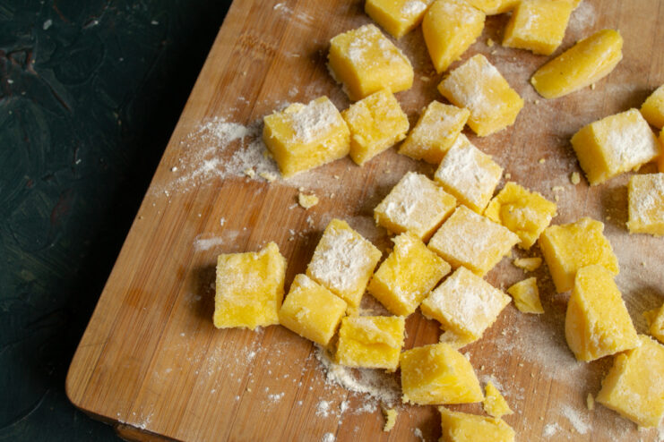 Dredging The Polenta Polenta cubes tossed in wheat flour on a cutting board