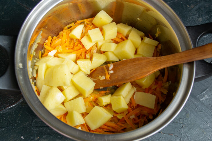 Adding diced potatoes Raw diced potatoes added to the sauteed carrots and onions