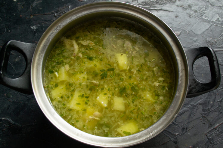 Final soup assembly Adding shredded chicken meat back into the pot of hot soup