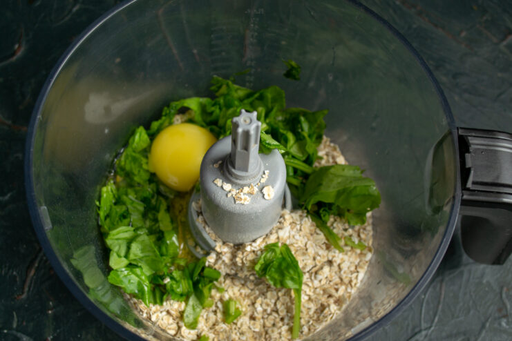 Adding the egg Raw egg added to the spinach and oats