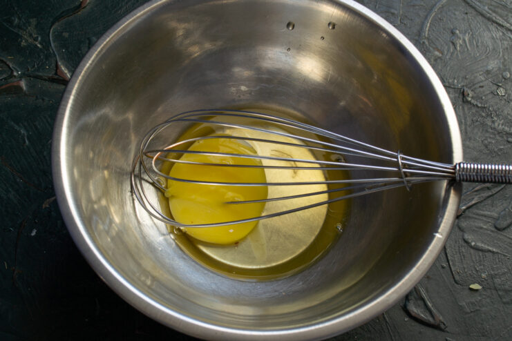 Whisking the egg A whisk mixing an egg in a bowl for the batter.