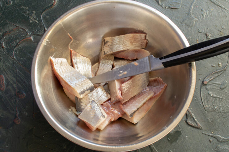 Chopping the fish Chopped herring fillets in a metal bowl