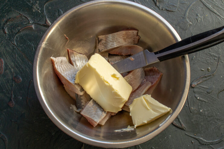 Adding butter Herring pieces with butter in a bowl