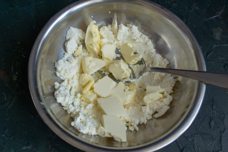 Diced butter added to ricotta in a bowl