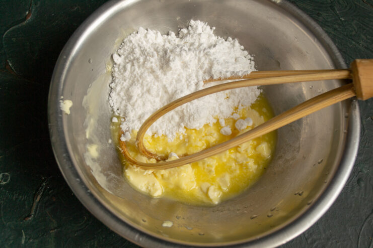 Butter and powdered sugar Cubed butter and powdered sugar sitting in a mixing bowl.