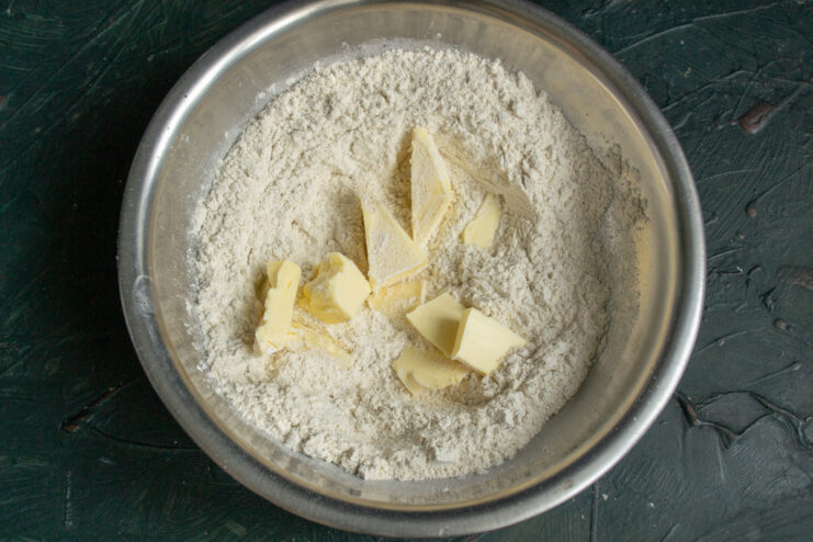 Adding Butter to Flour Cubes of butter resting in a flour mixture