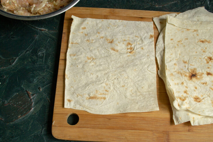 Cutting thin Armenian lavash flatbread into small rectangular pieces