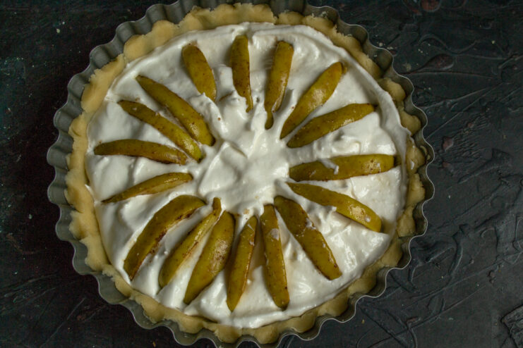 Arranging the apples Apple slices arranged on top of the cream filling in a pan