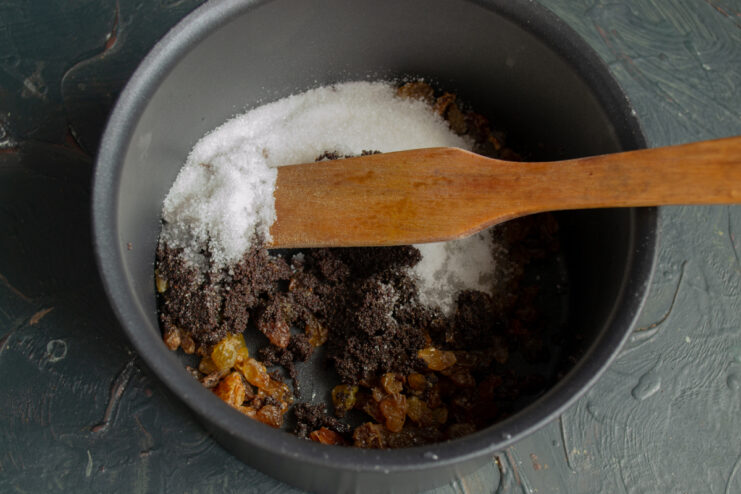 Mixing Filling Ingredients Poppy seeds, raisins, and sugar in a saucepan with a wooden spatula