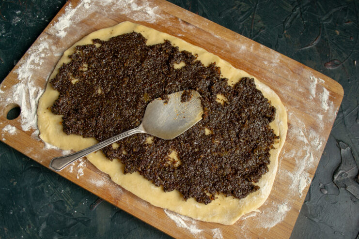 Spreading the Filling Dark poppy seed filling spread evenly over a rectangular sheet of dough