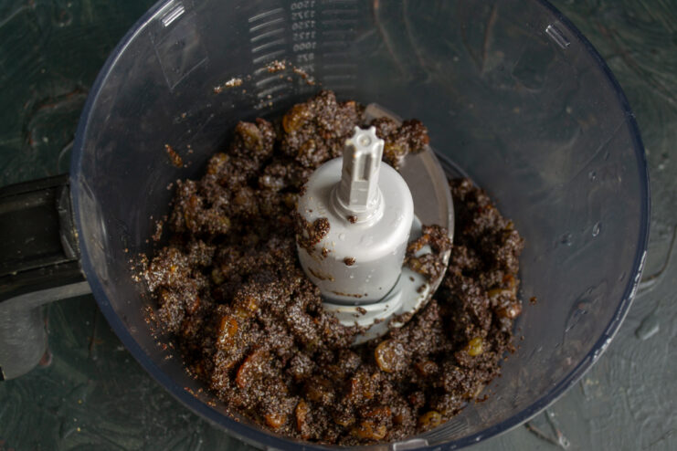 Preparing the Filling Thick poppy seed filling with raisins and dates inside a food processor bowl