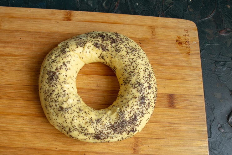 Shaping the Ring Poppy seed roll shaped into a ring on a cutting board