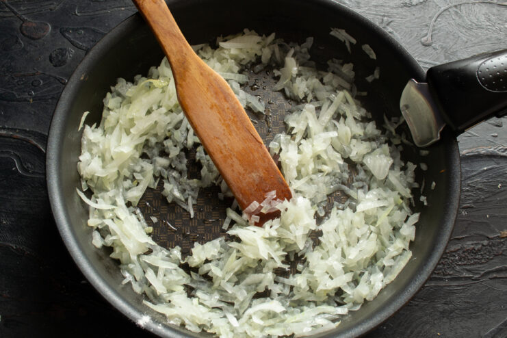 Sautéing the onions Finely diced onions sautéing in vegetable oil in a frying pan.