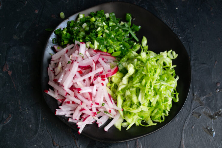Finely chopped scallions on a plate with vegetables