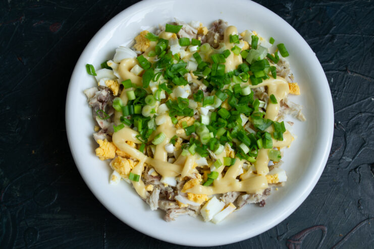 Adding green onions Finely chopped green onions layered over a mayonnaise grid