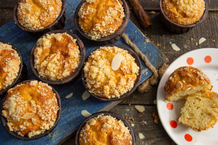 Golden almond, banana, and farmers cheese muffins on a blue board