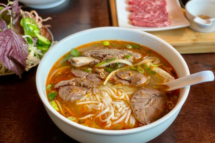 Spicy bun bo Hue noodle soup with beef Bowl of spicy bun bo Hue soup with beef and thick round rice noodles.