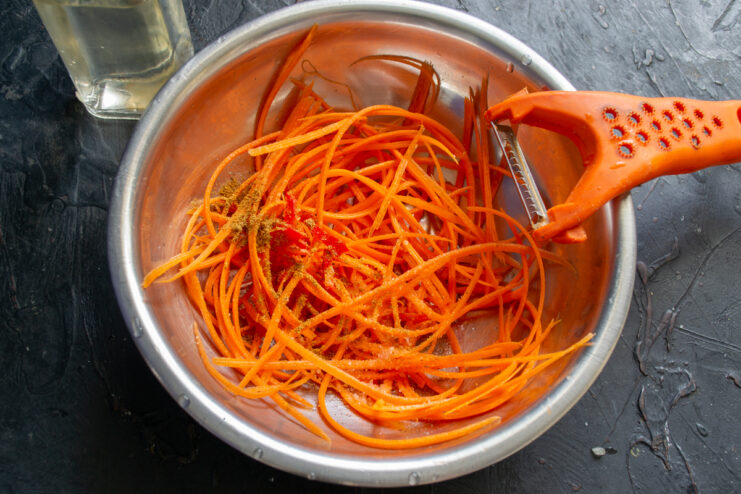 Marinating The Carrots Carrots mixed with spices and chili pepper in a bowl