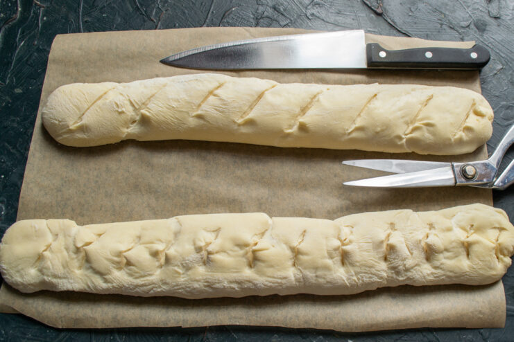 Scoring the baguette dough with diagonal cuts