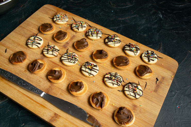Piping The Filling Spreading thick chocolate ganache onto the flat side of a cookie half