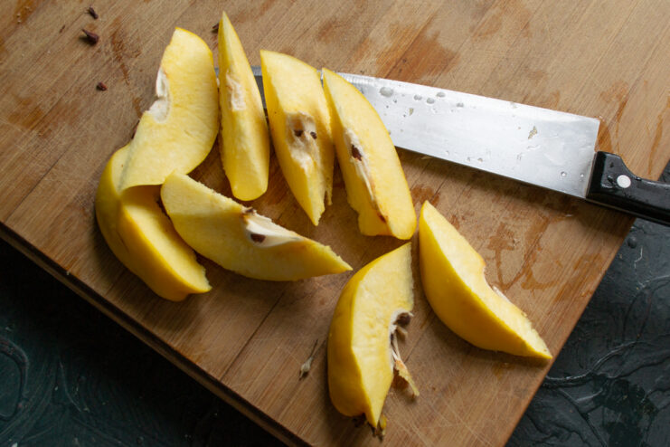 Slicing The Quince Freshly sliced quince wedges on a cutting board