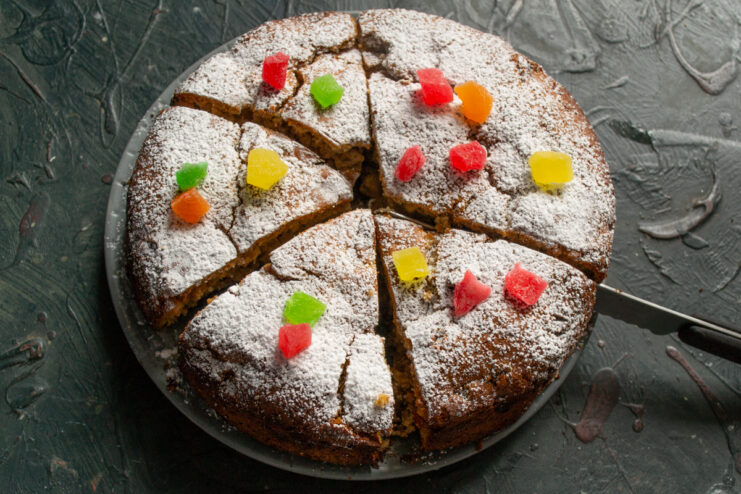 Sliced cake dusted with powdered sugar on a serving plate