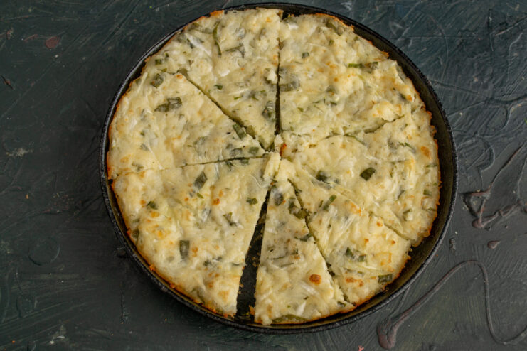 Slicing into portions Slicing the baked casserole into neat triangles directly in the skillet