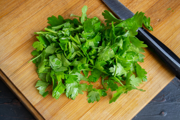 Prepping Cilantro for the Sauce Chopped fresh cilantro on a wooden cutting board