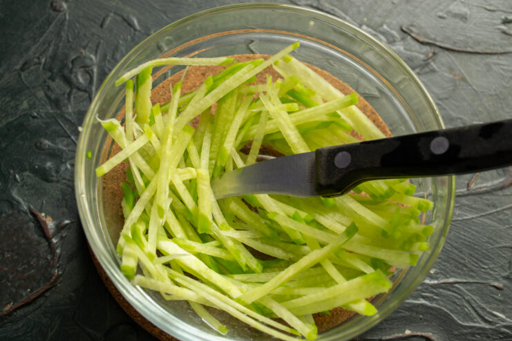 Preparing Green Radish Thinly julienned green radish in a glass bowl