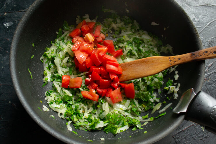 Adding Tomatoes Diced tomatoes in a skillet