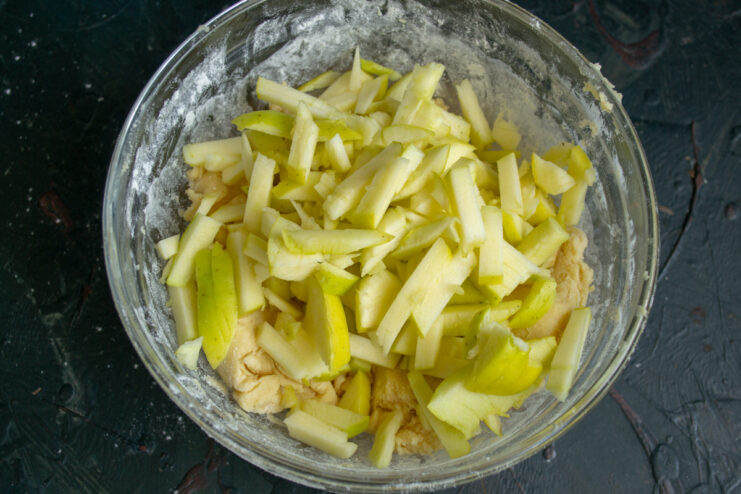 Chopped apple pieces sitting on top of the cookie dough