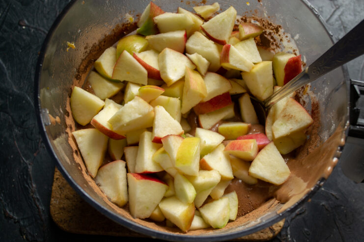 Folding in the apples Mixing diced apples into the chocolate batter with a spoon