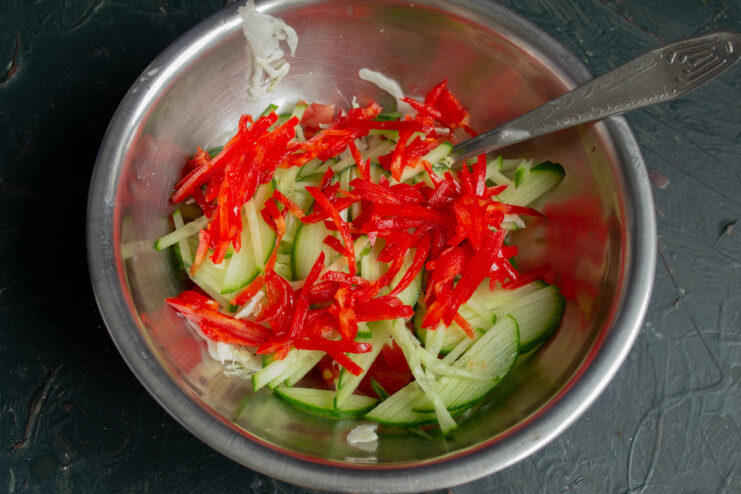 Prepping the vegetable filling Diced bell peppers and cucumbers in a bowl