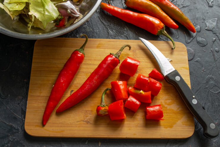 Chopping the chili peppers Roughly chopped red chili peppers on a cutting board