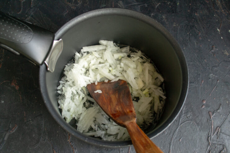 Sautéing the onions Finely chopped onions cooking in a pot with oil.