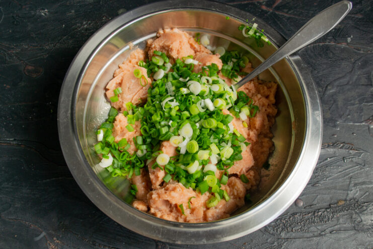 Adding green onions Chopped green onions placed on top of minced fish.
