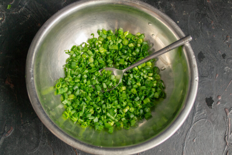 Prepping the scallions Finely chopped scallions in a metal mixing bowl