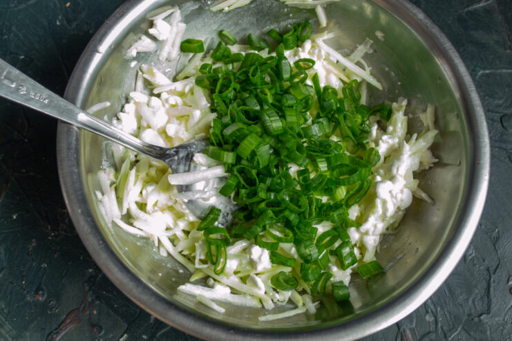 Adding scallions Chopped green scallions mixed into the zucchini and cheese batter