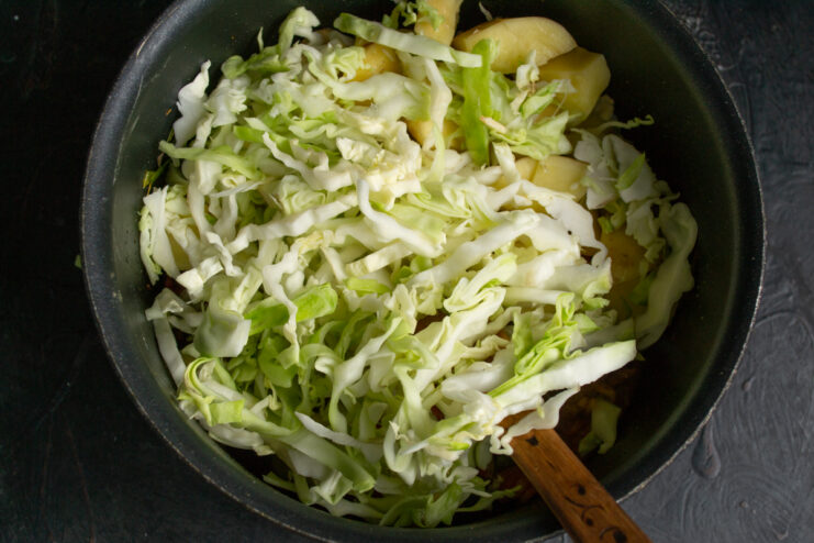 Adding Cabbage Shredded fresh green cabbage added to the soup pot.