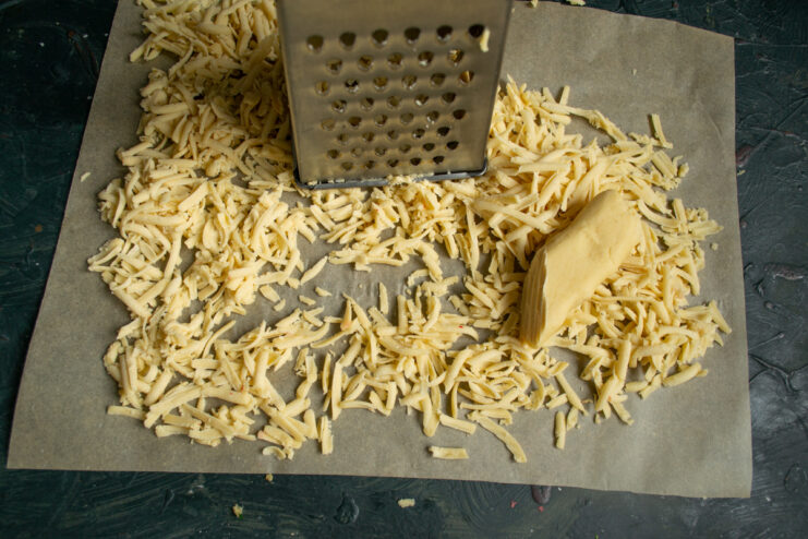 Grating the dough Grating frozen dough onto parchment paper using a coarse box grater