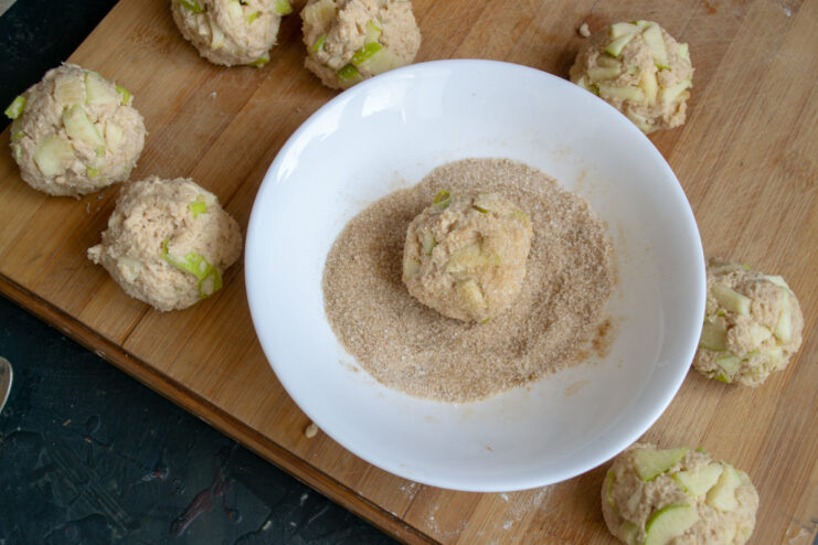 Rolling a dough ball in a cinnamon sugar mixture