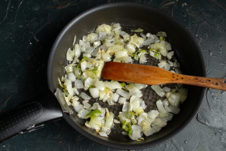 Softened and aromatic onions, garlic, and hot pepper sautéing in a skillet