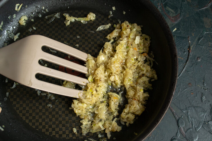 Preparing The Dressing Sautéed chopped onions in a frying pan