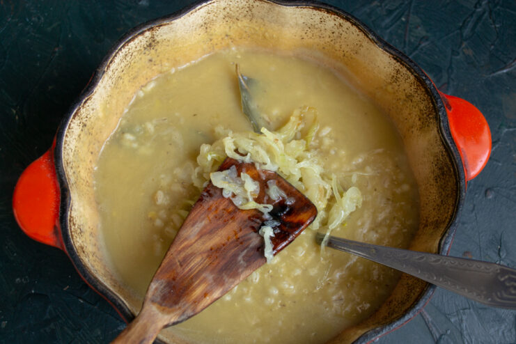 Stirring in Caramelized Onions Adding golden caramelized onions to the pot of kulesh