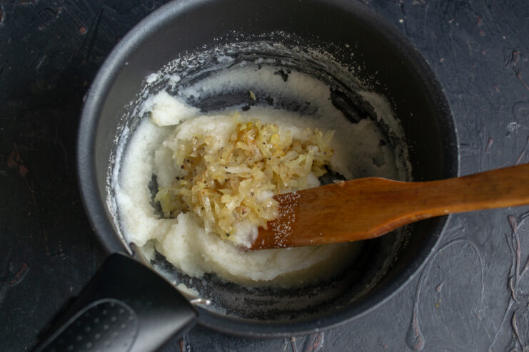 Adding sautéed onions Sautéed chopped onions added to the thick semolina porridge