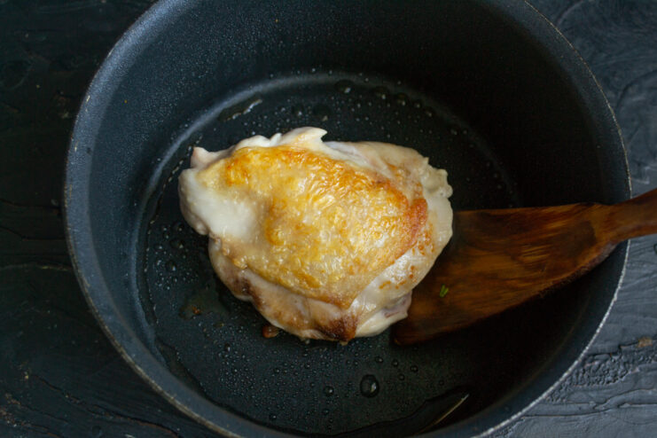 Searing The Chicken Browning a chicken thigh in a heavy-bottomed pot